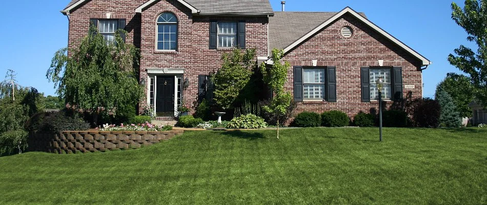 Large brick house in Cascade, MI, and a green front lawn.
