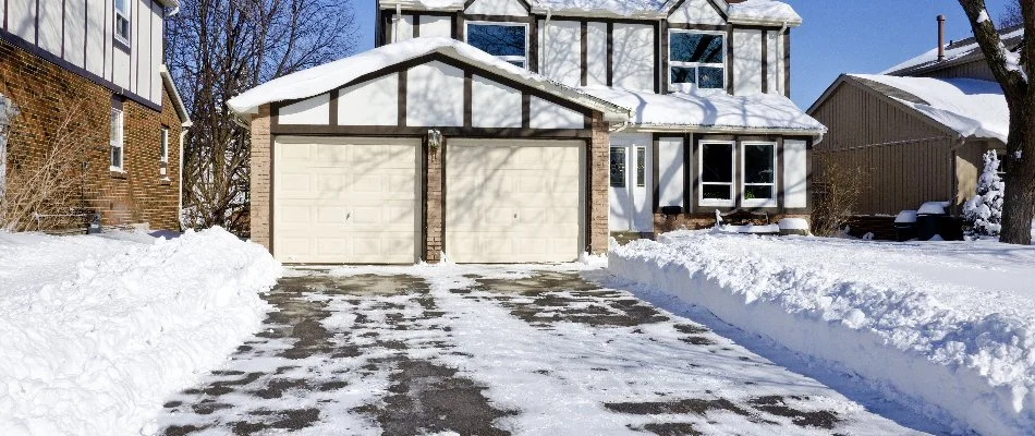 Snow-covered house in Cascade, MI, with a cleared driveway.